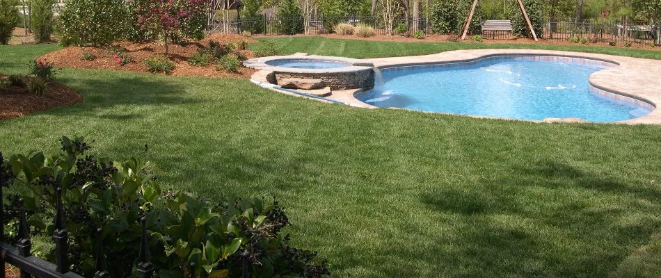 Well-manicured lawn near a pool on a property in New Hill, NC.