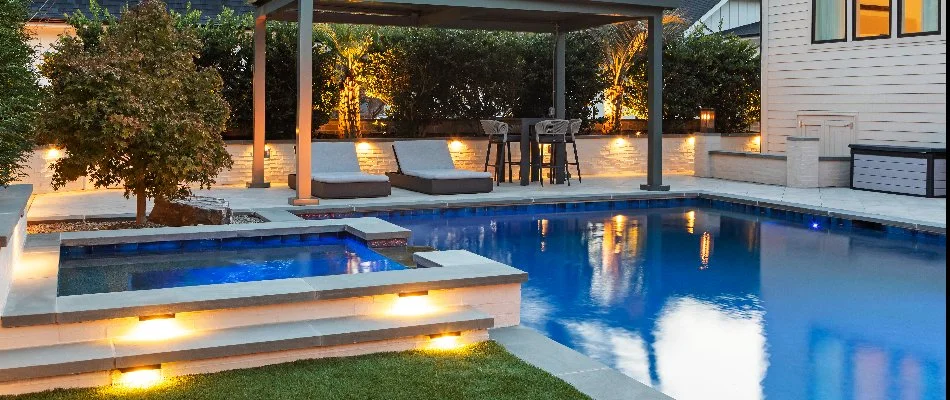 Lighting along a pool and outdoor living features in Cary, NC.