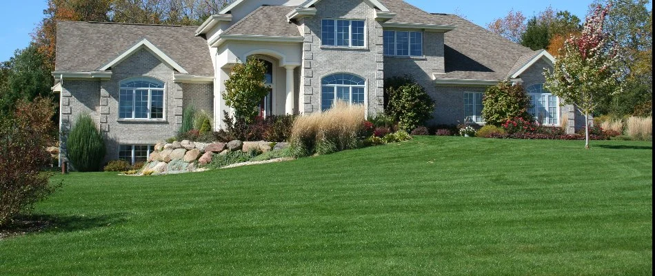 A large house in Cary, NC, with a manicured lawn and plants.