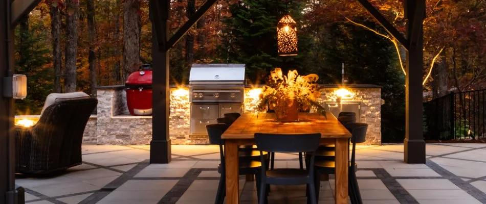 Outdoor kitchen with a grill and dining table in Cary, NC.