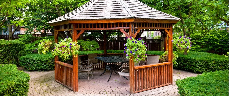 Gazebo in Cary, NC, on a paver patio with shrubs and plants.