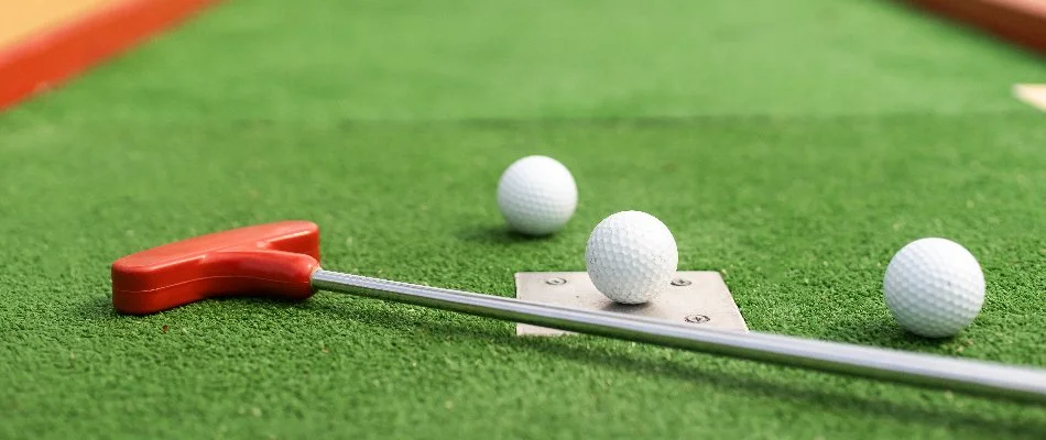 Putter and golf balls on artificial turf as putting greens in Cary, NC.