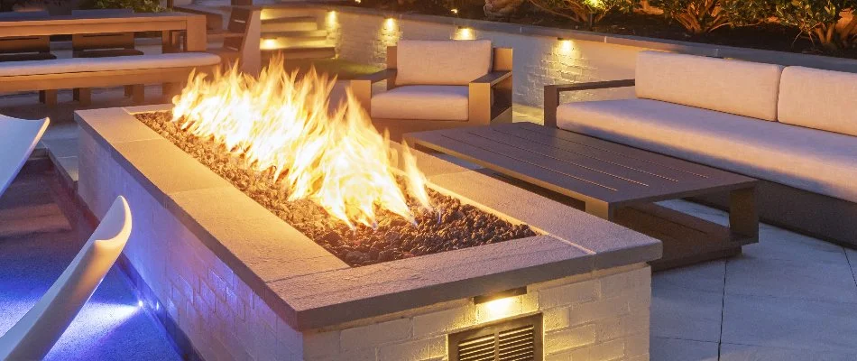 Rectangular fire pit in Cary, NC, surrounded by chairs.