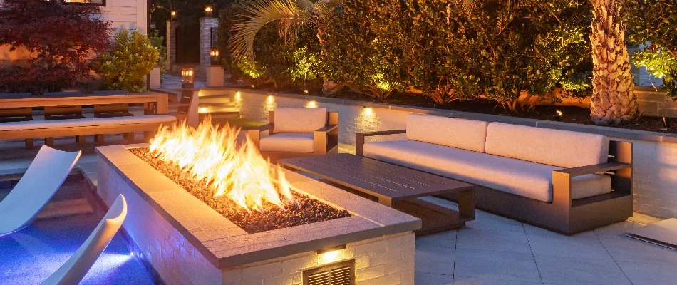 Rectangular gas fire pit in Apex, NC, with chairs and plants around.