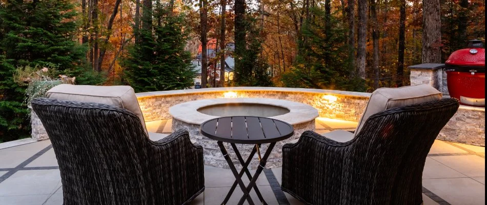 A seating wall and matching fire pit in front of woods in Hillsborough, NC.