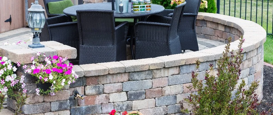 Seating wall around a patio in Cary, NC, with furniture and plants.