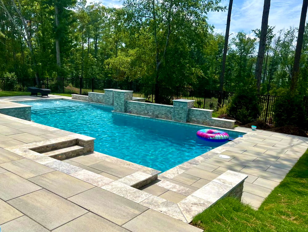 A pool and hardscaping backyard that was built by Agape Lawn Care Company